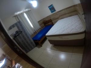 1 dormitorio pequeño con 1 cama y 1 silla en cabo frio barato, en Cabo Frío