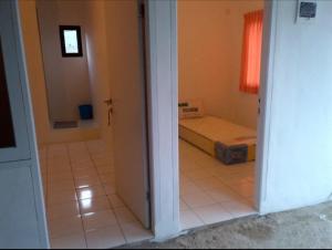 une porte menant à une chambre avec un lit dans une pièce dans l'établissement Guesthouse Maura, à Pondokcina