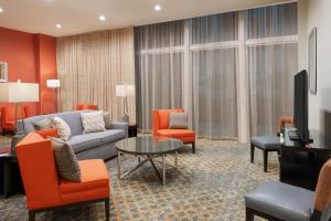 a living room with a couch and chairs and a tv at Staybridge Suites - Miami International Airport by IHG in Miami