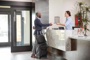 a man and a woman shaking hands at a counter at Staybridge Suites - Miami International Airport by IHG in Miami