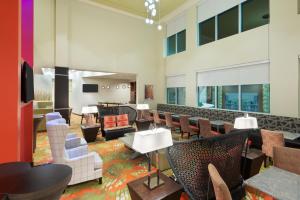 マイアミにあるStaybridge Suites - Miami International Airport by IHGのロビー(椅子とテーブルのある待合室付)
