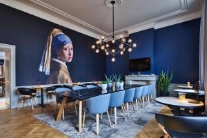 デン・ハーグにあるStaybridge Suites The Hague - Parliament, an IHG Hotelの女性絵画のダイニングルーム