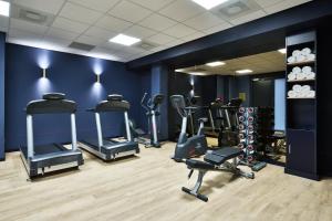 a gym with several tread machines in a blue wall at Staybridge Suites The Hague - Parliament, an IHG Hotel in The Hague