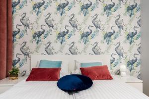 1 dormitorio con 1 cama con papel pintado de pájaro en Sleepway Apartments - Strzelecka 29A-15 en Poznan