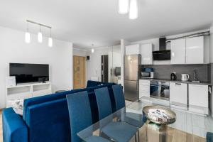 sala de estar con sofá azul y mesa de cristal en Sleepway Apartments - Strzelecka 29A-15 en Poznan