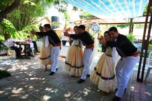 a group of men dancing in front of a table at La Quinta in Piribebuy