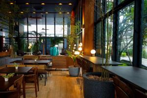 Seamira House Huahin - SHA في هوا هين: مطعم بطاولات وكراسي ونوافذ كبيرة
