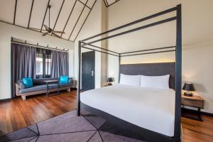 a bedroom with a large bed and a couch at Avani Sepang Goldcoast Resort in Sepang