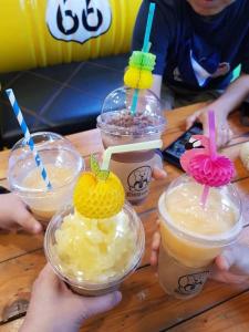 a group of people holding up plastic cups with drinks at Somrudee Resort in Nakhon Nayok