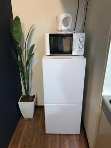 a microwave sitting on top of a white refrigerator at Ostay Kitahama Hotel Apartment in Osaka