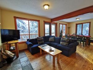 a living room with a blue couch and a tv at Alpine Meadows Lodge in Golden