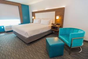 a hotel room with a bed and a blue chair at Holiday Inn Express Hollywood Walk of Fame by IHG in Los Angeles