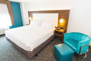 a hotel room with a bed and a blue chair at Holiday Inn Express Hollywood Walk of Fame by IHG in Los Angeles
