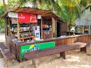 a drink stand on the beach with a bench at Scorpion Hill Lodge in Busua