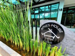 a sign in front of a building with plants at Ama's House Luxury Boutique Hotel in Chiang Mai