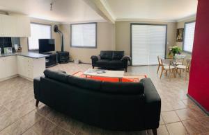 a living room with a black couch and a table at Cottage in the Country in Tumut