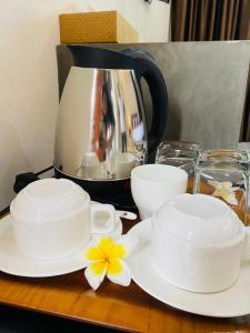 Ban Bo Thong的住宿－Dark Sugar Resort，桌子上放两个白杯和碟子,配有咖啡壶
