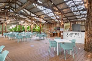 a restaurant with tables and chairs in a building at Ramada Resort by Wyndham Port Douglas in Port Douglas