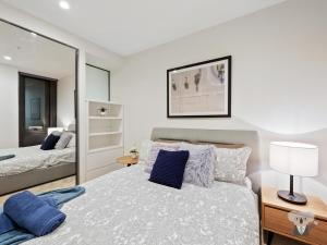 un dormitorio con una cama y un espejo en KOZYGURU MELBOURNE CITY PERFECT TRANQUIL SANCTUARY 1 BED APT VME023, en Melbourne 4 fotos más