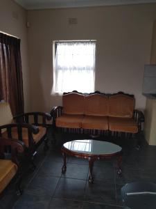 ein Wohnzimmer mit einem Sofa und einem Couchtisch in der Unterkunft Henry's House On Sea in Hibberdene