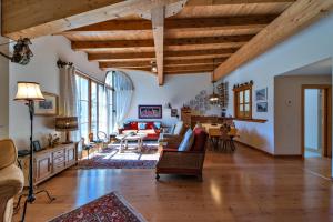 a large living room with wooden ceilings and wooden floors at Chesa Roseg - Pontresina in Pontresina