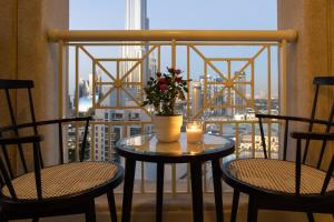 a table with a candle and flowers on a balcony at 2BR 42nd Floor, Tranquil Spot Burj Khalifa View, 29 Boulevard Tower 1 in Dubai