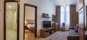 Sala de estar con cama y TV en Hotel Star, en Mukácheve