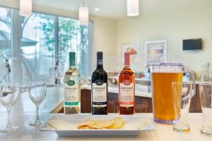 three bottles of wine and chips on a table with glasses at Staybridge Suites - Miami International Airport by IHG in Miami