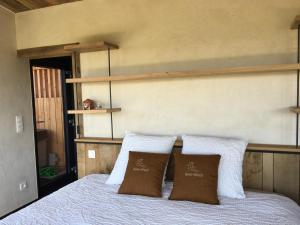 una camera con un letto con due cuscini sopra di Beau Réveil nature & wellness - gite 1 a Manhay