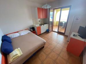 a bedroom with a bed and a desk and a kitchen at Apartments Viktor in Ražanj