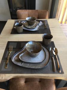 un tavolo di legno con tre ciotole e piatti sopra di Beau Réveil nature & wellness - gite 1 a Manhay