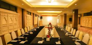 a long table in a room with white chairs and tables at Hotel The Kantipur in Pokhara