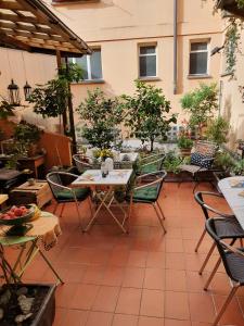un patio al aire libre con mesas, sillas y árboles en Garni Giacometti en Locarno