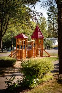 - une aire de jeux avec 2 équipements de jeux en bois dans un parc dans l'établissement Camping Ettelbruck, à Ettelbruck
