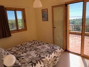 a bedroom with a bed and a balcony at Casa Mola in Perelló +27 photos