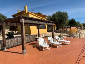 a group of white chairs and a table and a pavilion at Casa Mola in Perelló
