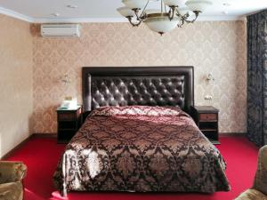 a bedroom with a bed and a chandelier at GK Grand-Hotel in Kislovodsk