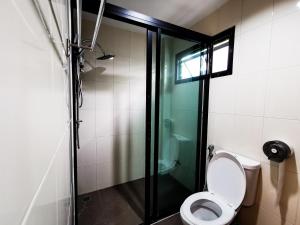 uma casa de banho com um WC e uma cabina de duche em vidro. em QG Resort em Lat Krabang