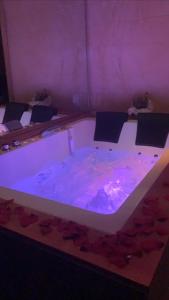 bañera grande con luces moradas en una habitación en Luxury Living Suite B&B, en Adelfia