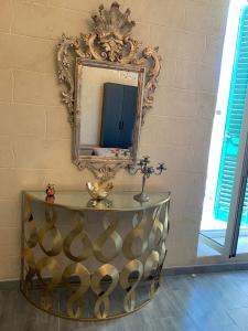 un espejo en una pared junto a una mesa en Luxury Living Suite B&B, en Adelfia