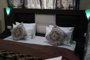 a bed with two pillows on top of it at Hotel Samar in Srinagar