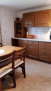 a kitchen with wooden cabinets and a wooden table and chairs at Ferienhaus Andrea Höcherl in Wolkenstein