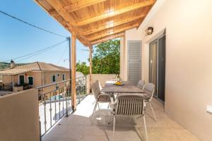 patio con mesa y sillas en el balcón en Asteria Apartments, en Meganisi