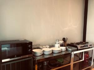 a kitchen with a microwave and plates on a counter at Rumah Kahyangan in Canggu