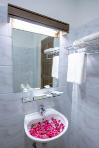 a bathroom with a sink filled with pink flowers at UCT Taunggyi Hotel in Taunggyi
