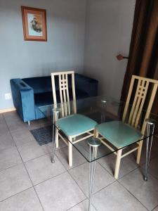 szklany stół z 2 krzesłami i kanapą w obiekcie The Manderson Hotel and Conference Centre w mieście Stutterheim