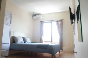 a bedroom with a bed and a window at bumimakhraja syariah 4 in Bandung