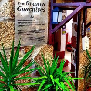 ベルモンテにあるBranca Gonçalves Belmonteの壁の看板の横に座る植物