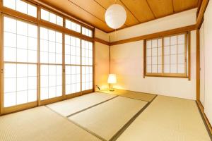 a large room with large windows and a lamp at NAVI Azabujuban in Tokyo