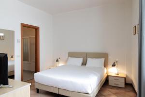 a bedroom with a white bed and a television at Residenza Cavour in Parma